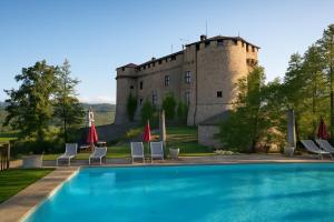 a villa with a swimming pool in front of a castle at La vista sul Castello in Cerreto