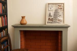 a fireplace with a picture and a vase on top at La vista sul Castello in Cerreto