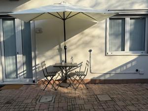 a table and chairs under an umbrella on a patio at Casa Dina in Baveno
