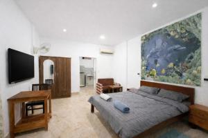 a bedroom with a bed and a large painting on the wall at Expat Resort in Siem Reap