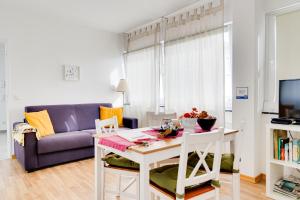 a living room with a table and a purple couch at B&B MY PLACE mit Frühstückspaket - with Breakfastbox in Frankfurt