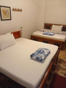 two twin beds in a room withthritisthritisthritisthritisthritisthritisthritisthritisthritis at Villa Luxez in Kalmunaikudiyiruppu