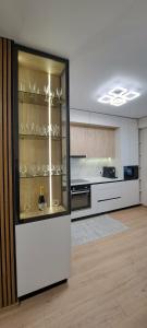 a kitchen with a glass display case with wine glasses at SkyHouse&PrivateGarage in Chişinău +7 photos