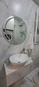 a white bathroom with a sink and a mirror at SkyHouse&PrivateGarage in Chişinău