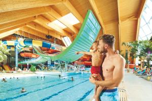 a man and a boy standing in a swimming pool at Ferienwohnungen Hirschen in Löffingen