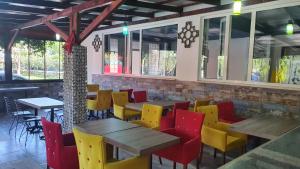 a restaurant with wooden tables and colorful chairs at Sun Rose Pansiyon in Pamukkale