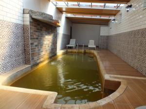 a large pool of water in a room with chairs at Sun Rose Pansiyon in Pamukkale