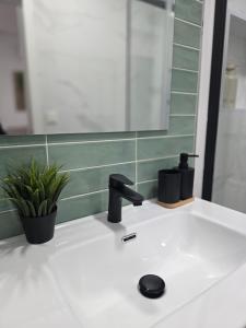 a bathroom sink with a faucet and a mirror at Estudio Luminoso AM in Bollullos par del Condado +14 photos