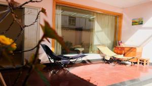 a living room with two chairs and a table at Kulikuli Boy's Inn in Lijiang