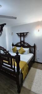 a bedroom with a black bed with yellow pillows at Shanzu Beach Homes 105 in Mombasa +19 photos