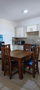 a wooden table and chairs in a kitchen at Shanzu Beach Homes 105 in Mombasa