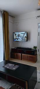a living room with a table and a tv on the wall at Shanzu Beach Homes 105 in Mombasa