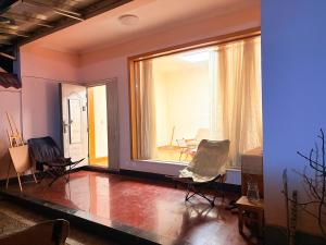 a room with chairs and a large window at Kulikuli Boy's Inn in Lijiang
