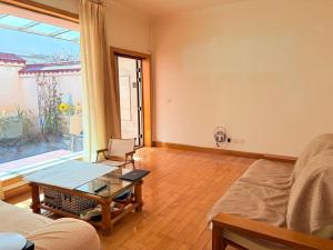 a living room with a couch and a table and a window at Kulikuli Boy's Inn in Lijiang +11 photos