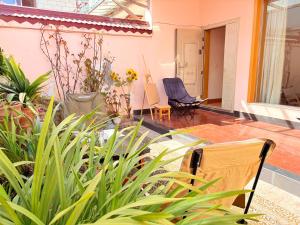 a patio with chairs and plants in a house at Kulikuli Boy's Inn in Lijiang
