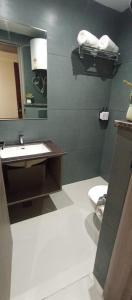 a bathroom with a sink and a toilet at AairHotel in Karnal