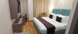 a hotel room with a large bed and a television at AairHotel in Karnal
