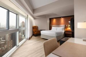 a hotel room with a bed and a desk at Millennium Hilton New York One UN Plaza in New York +68 photos