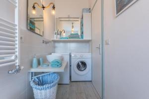 a small bathroom with a washing machine and a sink at GuestHost - Parco del Sole Residence Flat with Terrace in lido degli scacchi