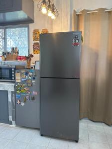 a refrigerator with magnets on it in a kitchen at Oslob Cozy Home in Oslob +8 photos