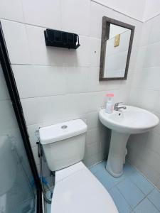 a white bathroom with a toilet and a sink at Oslob Cozy Home in Oslob