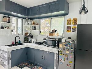 a kitchen with blue cabinets and a refrigerator at Oslob Cozy Home in Oslob