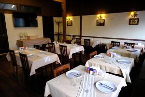 a dining room with tables and chairs with white table settings at Dünya Otel Adana in Seyhan