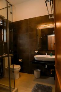a bathroom with a sink and a toilet and a mirror at Chamindu Villa Matara in Matara +48 photos