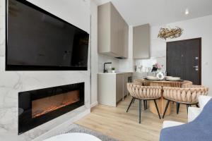 a living room with a fireplace and a table and chairs at Sol Marina Apartment by Solarento in Wiślinka