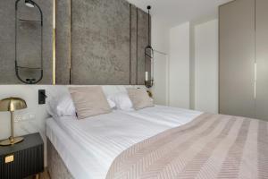 a bedroom with a large bed with white sheets at Sol Marina Apartment by Solarento in Wiślinka