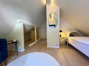 a attic bedroom with a bed and a mirror at Odda Gangdal Apartments in Odda
