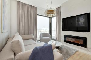 a living room with a couch and a fireplace at Sol Marina Apartment by Solarento in Wiślinka