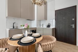 a kitchen with a dining room table and chairs at Sol Marina Apartment by Solarento in Wiślinka +18 photos