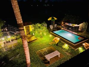 a backyard with a swimming pool at night at Wintergreen Water Front Resort- 5 Bedroom Villa in Tripunittura