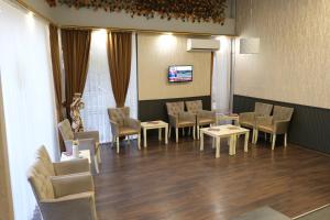 a waiting room with chairs and tables and a tv at Dünya Otel Adana in Seyhan