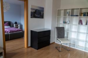 a bedroom with a bed and a dresser and a chair at Selina's Apartment in Oberthal
