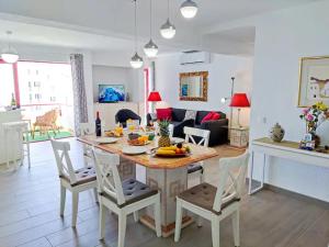 a kitchen and living room with a table and chairs at Vilamoura Condo facing the pool by Algarve Dream Holidays in Quarteira