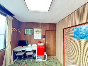 a room with a table with chairs and a computer at 媛楽園Himerakuen in Matsuyama