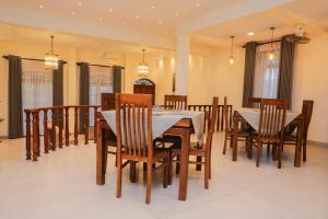 a dining room with a table and wooden chairs at Chamindu Villa Matara in Matara