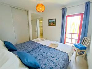 a bedroom with a blue bed and a window at Vilamoura Condo facing the pool by Algarve Dream Holidays in Quarteira +30 photos