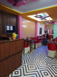 a lobby with a waiting room with tables and chairs at Dev Murti Eco Resort in Chālsa Mahābāri +26 photos