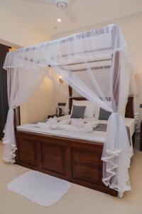a large bed with a canopy in a room at Chamindu Villa Matara in Matara