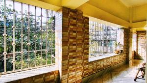 a room with two windows with a view of a garden at Maya's Crest in Howrah +8 photos