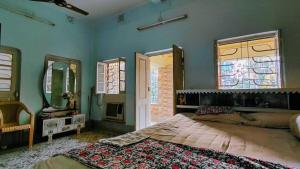 a bedroom with a large bed and two mirrors at Maya's Crest in Howrah