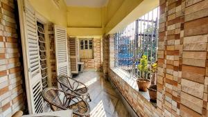 a balcony with two chairs and a window at Maya's Crest in Howrah
