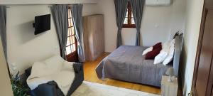 a bedroom with a bed and a tv and two windows at A&Bpikermistudios in Pikérmion