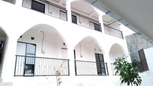 a large white building with arches and windows at Kims Stay Syariah in Jember