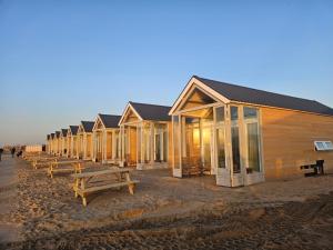 a row of wooden houses on the beach at Skip Inn Strandhuisjes in Katwijk aan Zee
