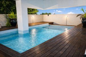a swimming pool in a house with a wooden deck at Oaks Penthouse - Flic en Flac in Flic-en-Flac
