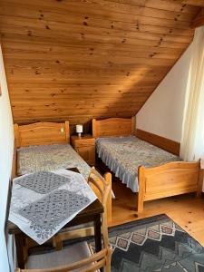 a room with two beds and a table in a cabin at Podkamiencem in Odrzykoń